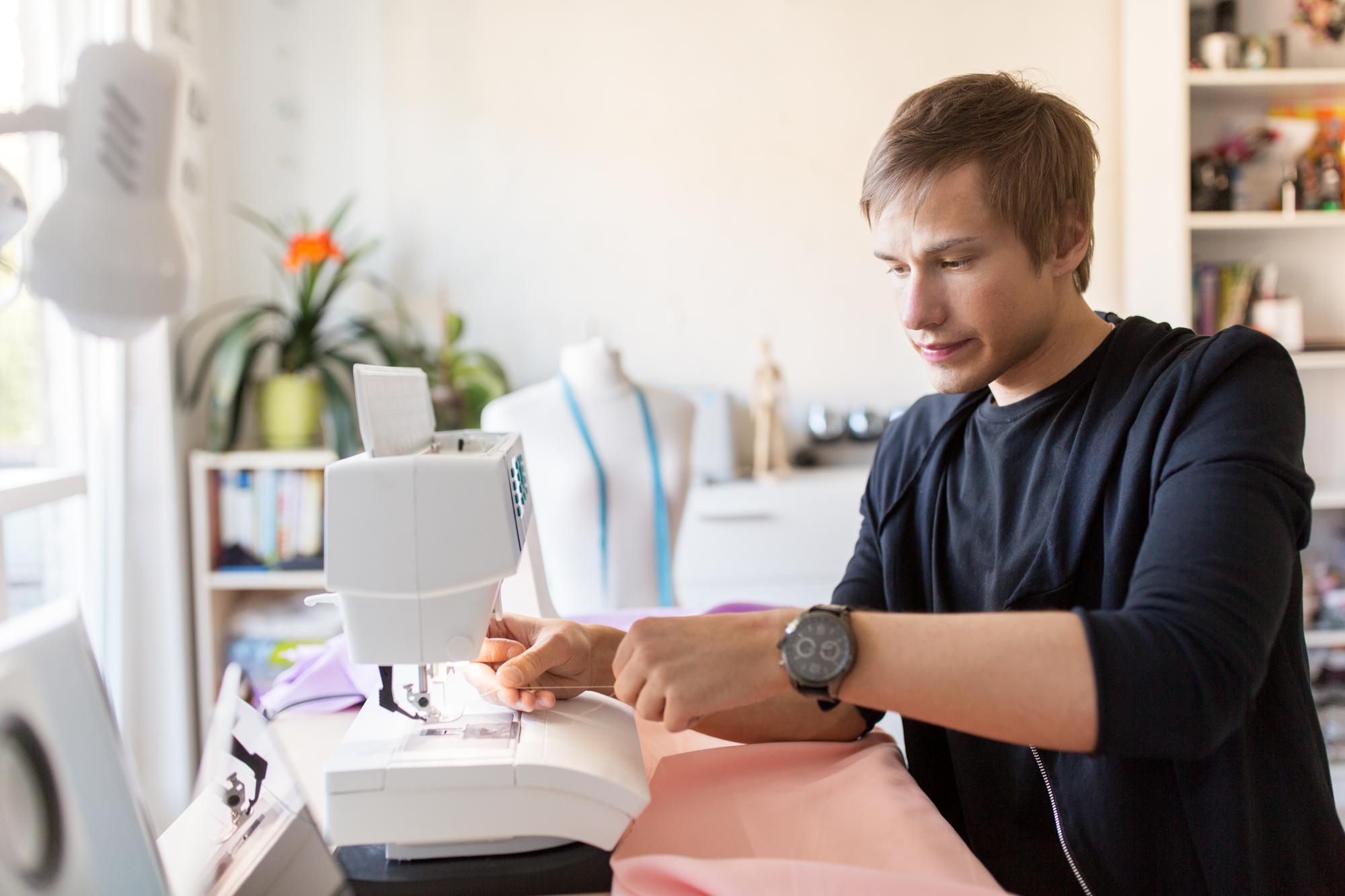 Artist adjusting embroidery machine in a modern workshop